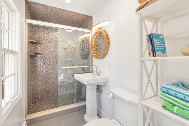 bathroom with toilet, plenty of natural light, tile patterned flooring, and walk in shower