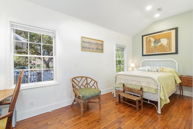 bedroom featuring multiple windows, wood-type flooring, and lofted ceiling