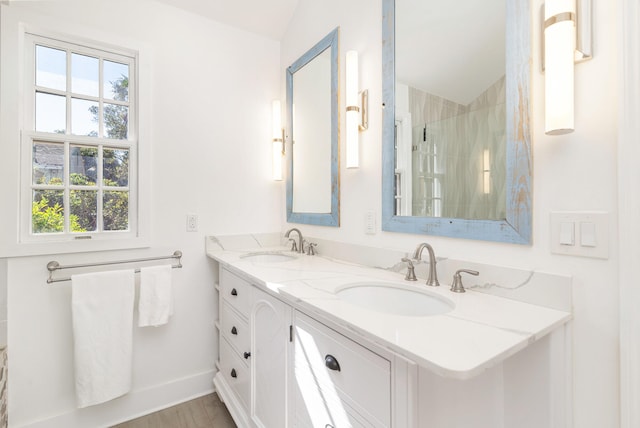 bathroom with hardwood / wood-style flooring, vanity, a tile shower, and lofted ceiling