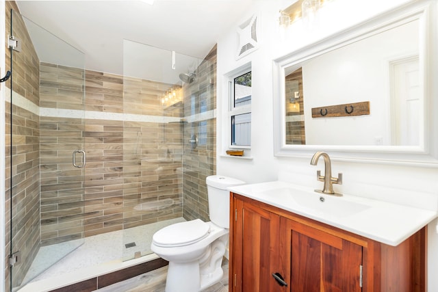 bathroom featuring wood-type flooring, vanity, toilet, and an enclosed shower