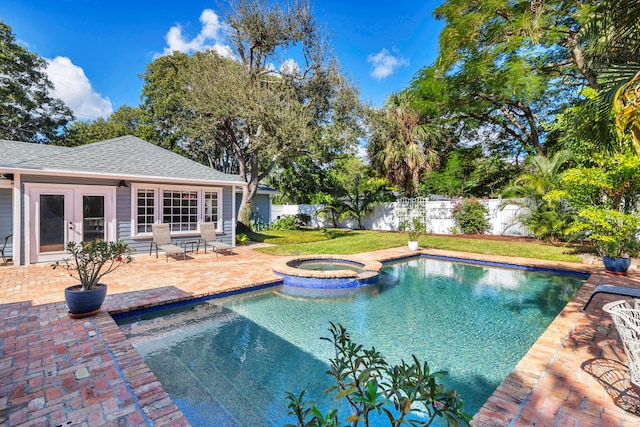 view of pool with a yard, an in ground hot tub, a patio, and french doors