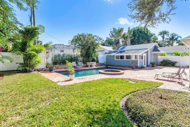 view of pool with an outbuilding, a patio area, a yard, and an in ground hot tub