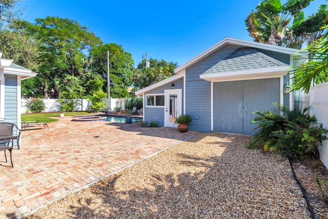 back of house featuring a pool with hot tub and a patio area