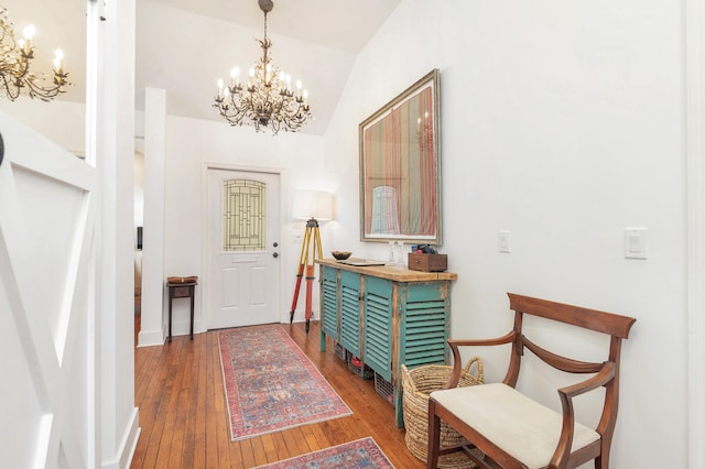 foyer featuring hardwood / wood-style floors, a chandelier, and lofted ceiling