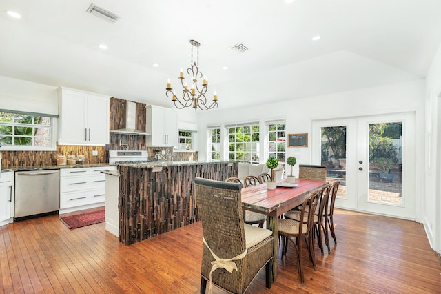 dining area featuring hardwood / wood-style floors, french doors, plenty of natural light, and lofted ceiling