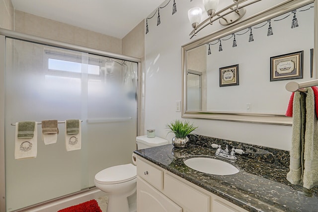 bathroom with vanity, toilet, and an enclosed shower