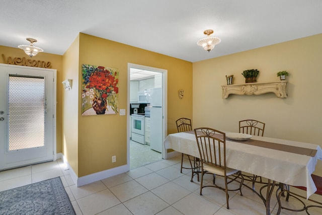 tiled dining space featuring a notable chandelier