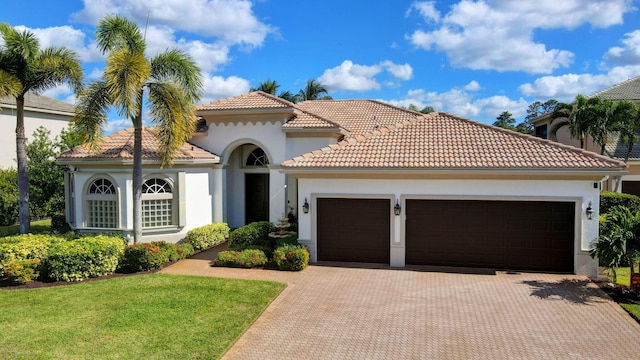 mediterranean / spanish home with a garage and a front yard