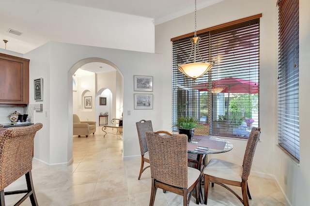 tiled dining space featuring crown molding