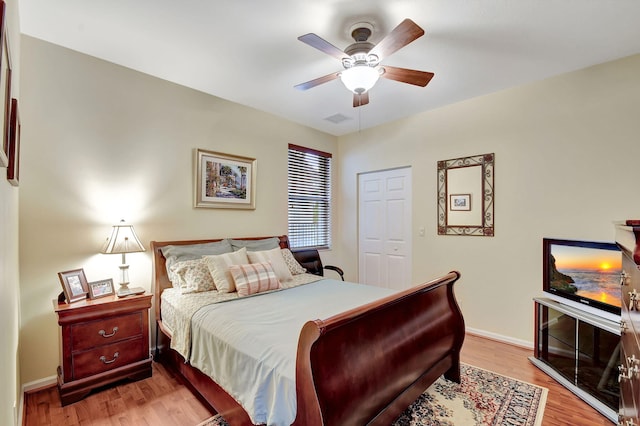 bedroom with a closet, light hardwood / wood-style floors, and ceiling fan