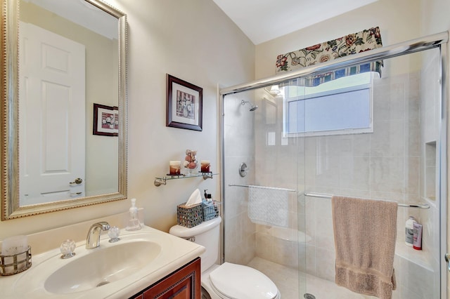 bathroom featuring a shower with door, vanity, and toilet