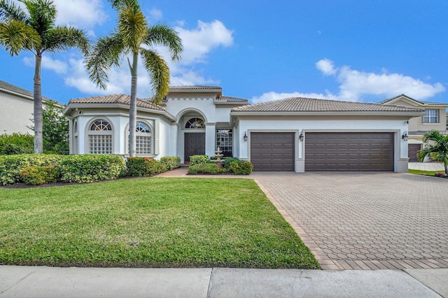 mediterranean / spanish-style home with a garage and a front yard