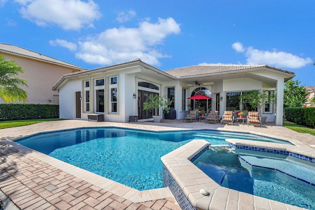 view of swimming pool with an in ground hot tub, ceiling fan, and a patio area