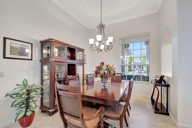 tiled dining room featuring a notable chandelier, a raised ceiling, and ornamental molding