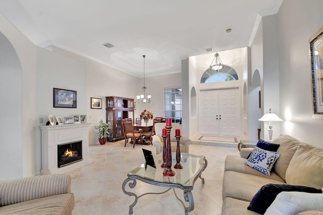 living room with an inviting chandelier, ornamental molding, and light tile patterned flooring