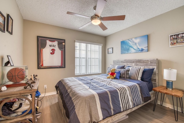 bedroom with wood finished floors, baseboards, a textured ceiling, and ceiling fan