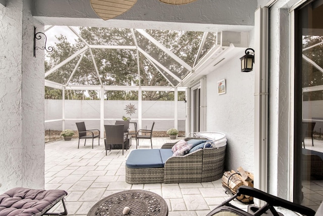 view of patio with glass enclosure and fence