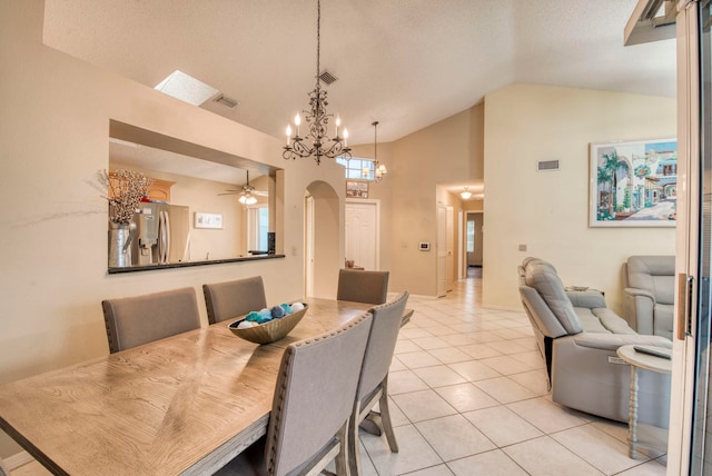 dining room featuring a textured ceiling, ceiling fan with notable chandelier, high vaulted ceiling, and light tile patterned flooring