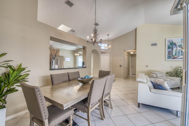 dining room with a chandelier, light tile patterned floors, arched walkways, ceiling fan, and baseboards
