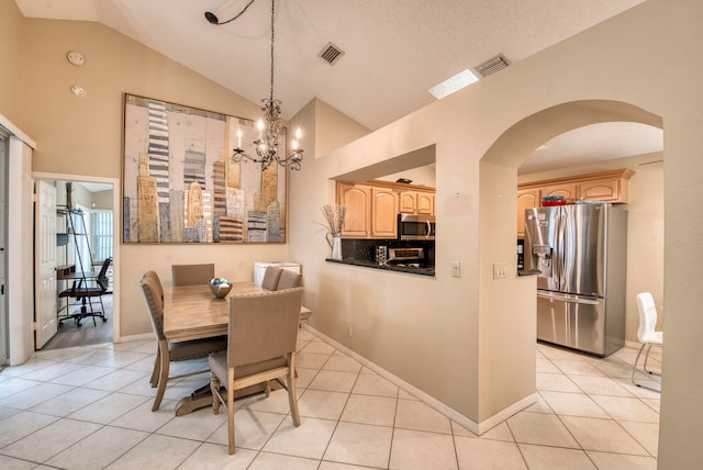 tiled dining space featuring a textured ceiling, vaulted ceiling, and a notable chandelier