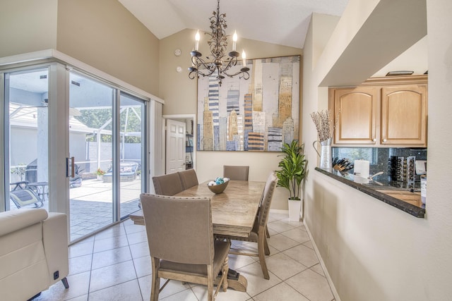 dining area with a chandelier, light tile patterned flooring, and high vaulted ceiling