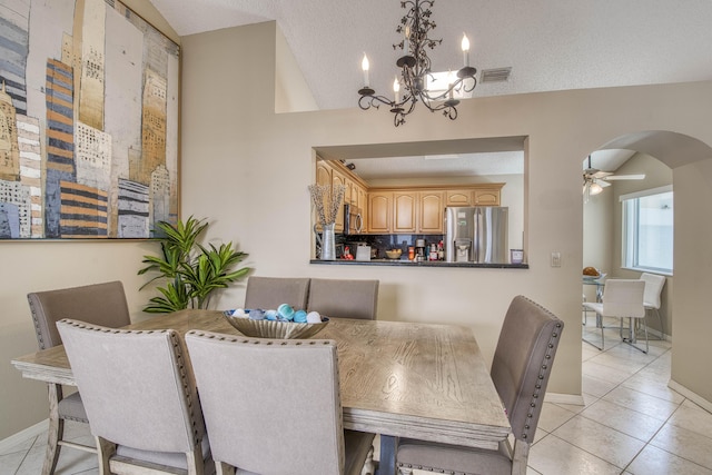 dining space with arched walkways, light tile patterned flooring, a chandelier, baseboards, and a textured ceiling