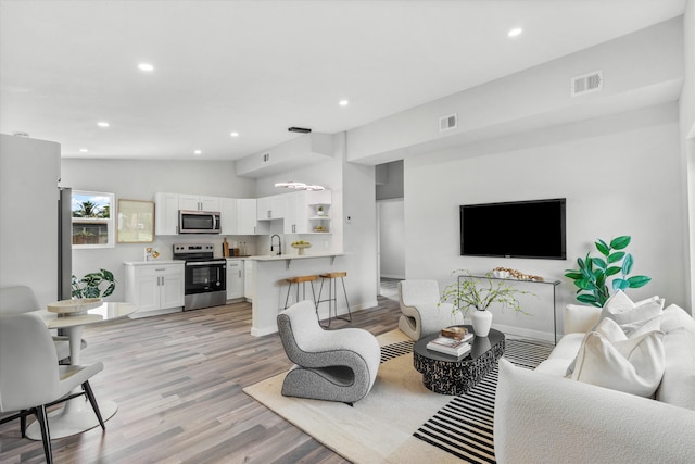 living room with light hardwood / wood-style flooring and lofted ceiling