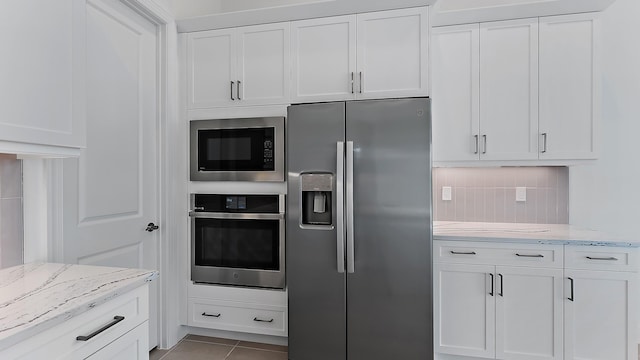 kitchen featuring white cabinets, stainless steel appliances, and tasteful backsplash