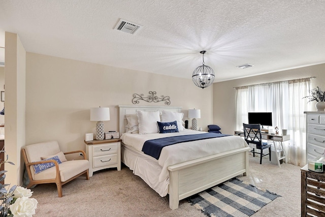 bedroom with a chandelier, a textured ceiling, and light colored carpet