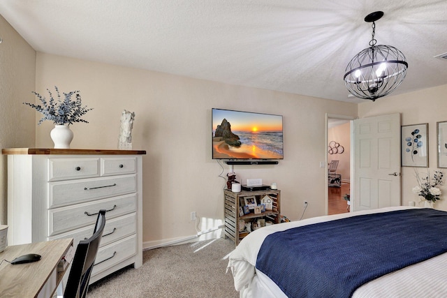 carpeted bedroom with a textured ceiling and a chandelier