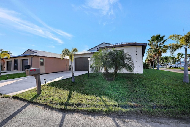 single story home with a garage and a front lawn