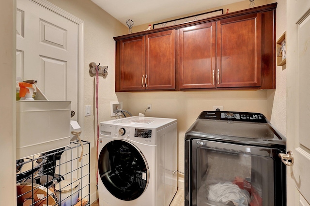 washroom featuring cabinets, washing machine and dryer, and sink