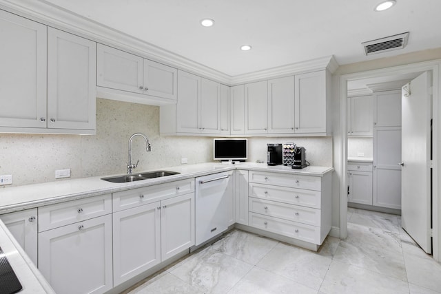 kitchen featuring sink, backsplash, white cabinets, and white dishwasher