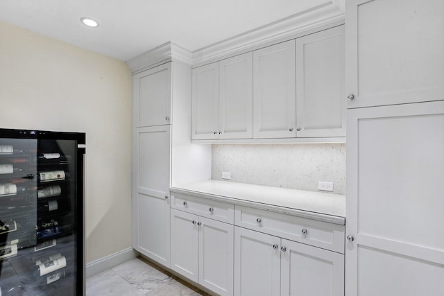 kitchen with backsplash, white cabinets, and beverage cooler