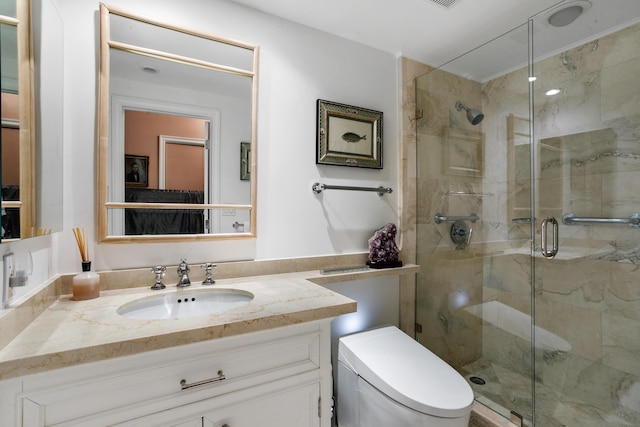 bathroom featuring vanity, a shower with shower door, and toilet