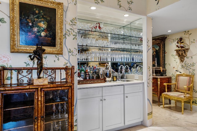 bar with white cabinets and sink