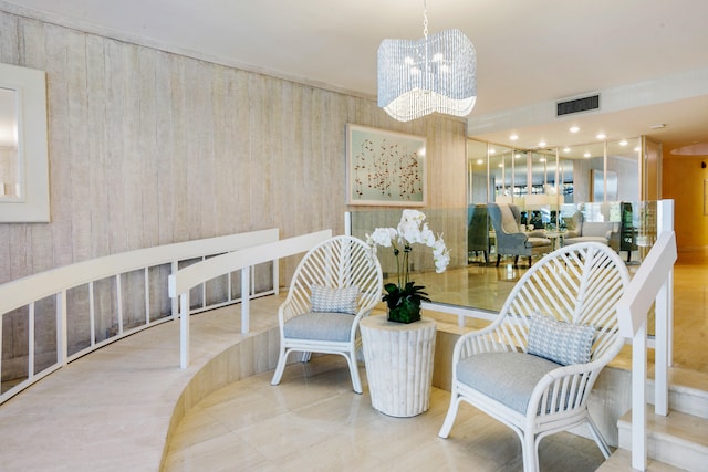 living area featuring tile patterned flooring and an inviting chandelier