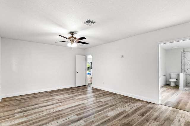 spare room featuring a textured ceiling, light hardwood / wood-style flooring, and ceiling fan