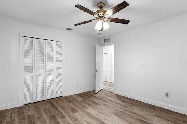 unfurnished bedroom with ceiling fan, a closet, and light hardwood / wood-style flooring