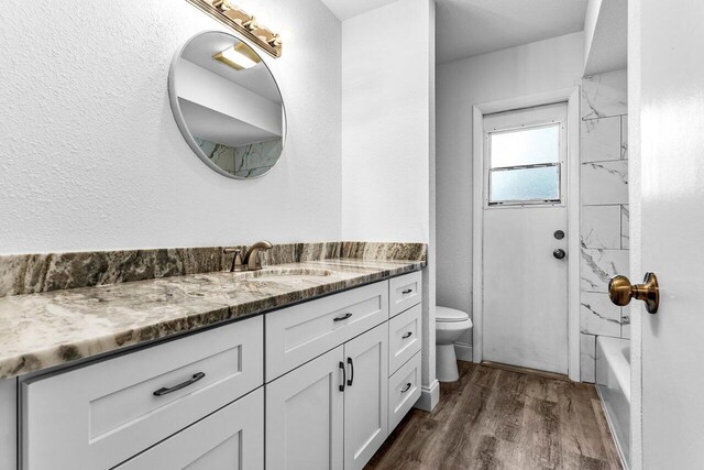 bathroom with hardwood / wood-style floors, vanity, and toilet