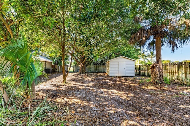 view of yard featuring central AC unit and a storage shed