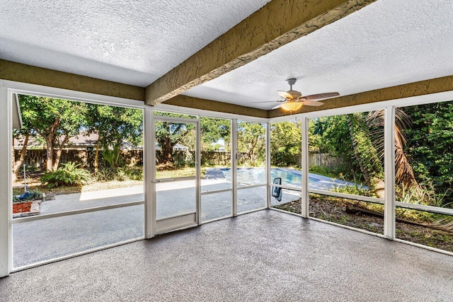 unfurnished sunroom featuring ceiling fan and beamed ceiling