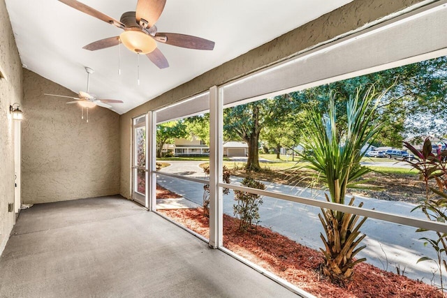 unfurnished sunroom featuring ceiling fan and vaulted ceiling