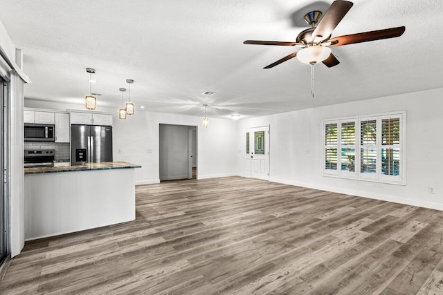 kitchen with ceiling fan, wood-type flooring, decorative light fixtures, white cabinets, and appliances with stainless steel finishes