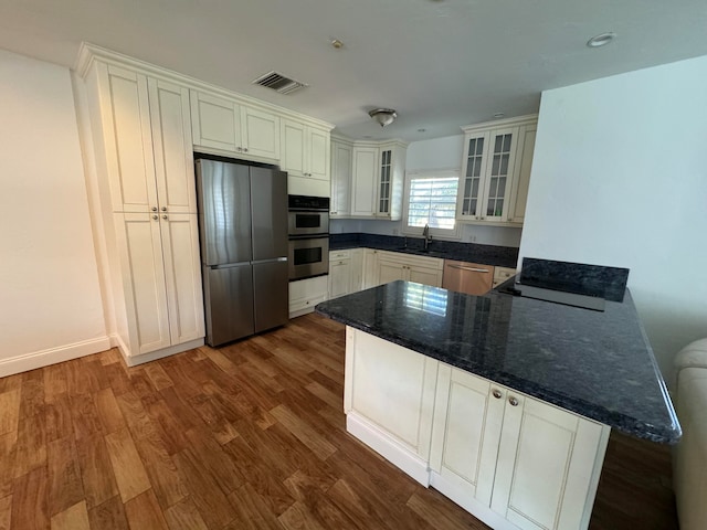 kitchen with white cabinetry, kitchen peninsula, stainless steel appliances, and dark wood-type flooring