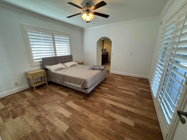 bedroom with ceiling fan, hardwood / wood-style floors, and ornamental molding