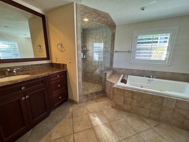 bathroom featuring tile patterned floors, vanity, separate shower and tub, and a textured ceiling