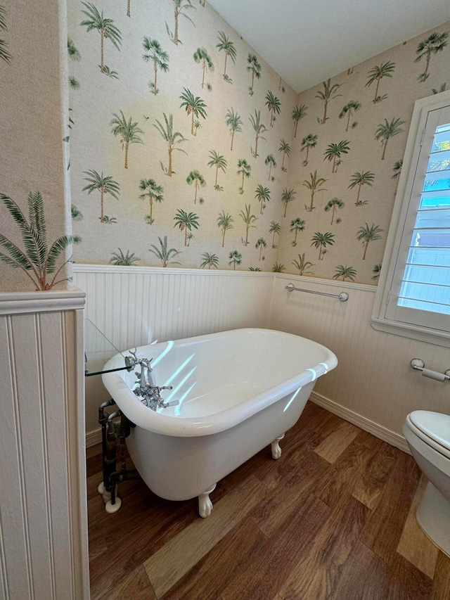 bathroom featuring a washtub, wood-type flooring, and toilet