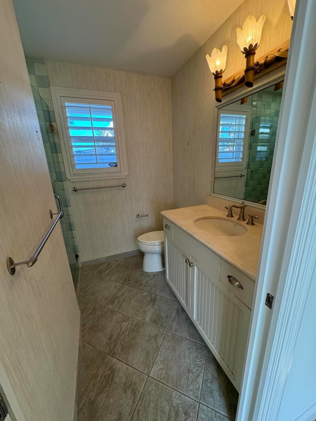 bathroom featuring tile patterned floors, vanity, a healthy amount of sunlight, and toilet