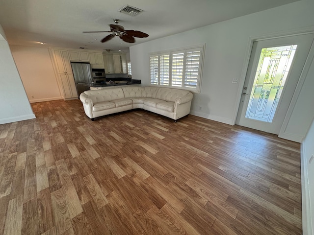 unfurnished living room featuring ceiling fan and wood-type flooring